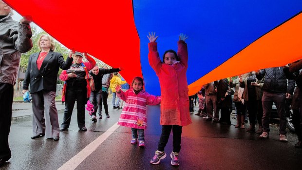 Sisters Leila, 3, and Natalie, 6, march through Chatswood under an Armenian flag to commemorate the 1915 genocide.