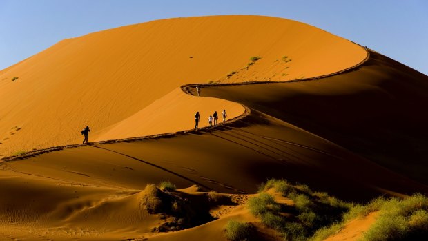 Tourists climbing Sossusvlei dune, Naukluft National Park, Namibia.