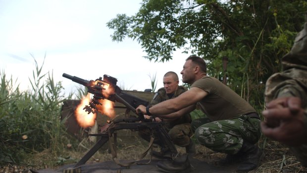 Ukrainian soldiers fire a grenade towards separatist fighters in Avdiivka in Ukraine's Donetsk region.