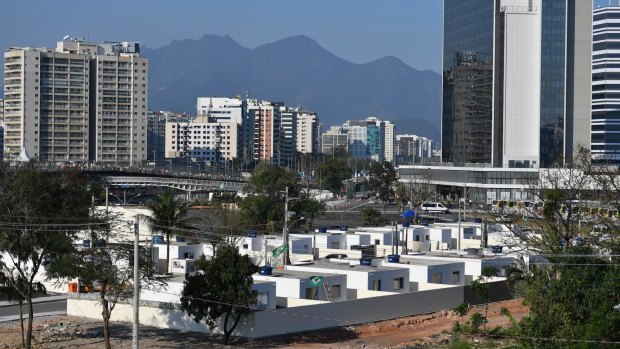 Vila Autodromo's identical houses share the gentrified Barra neighbourhood with the Olympic media centre (right) and apartments (background).