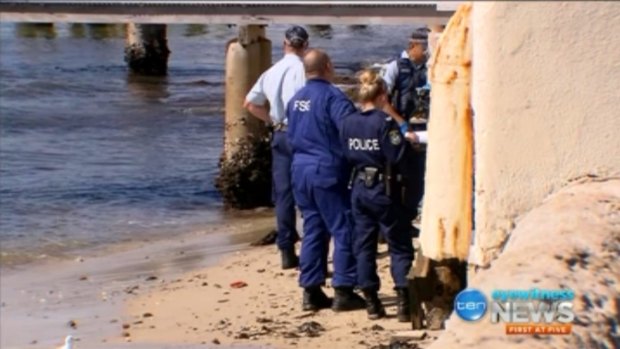 Police on a beach at Darling Point after a body was found in the water.