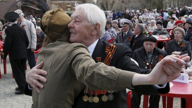An elderly man and a girl dance at a Victory Day party in the Siberian city of Krasnoyarsk.