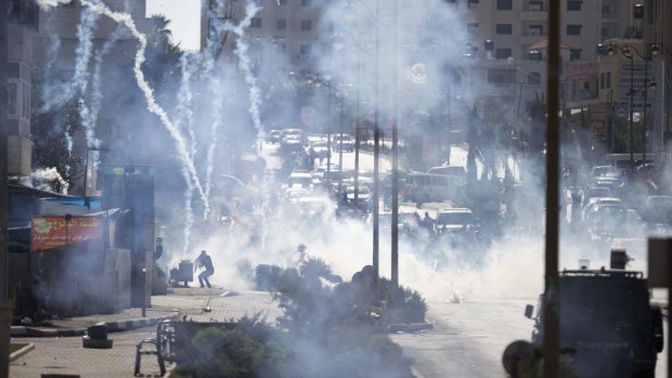 Israeli troops fire tear gas during clashes with Palestinian demonstrators near Ramallah, West Bank, on Friday.