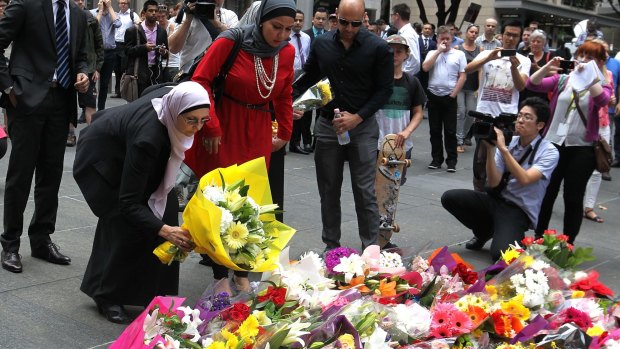 Members of the Muslim community lay flowers at Martin Place after two people were killed during the siege.