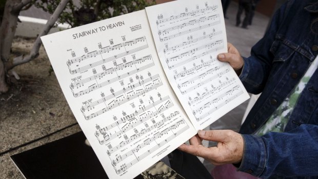 A Led Zeppelin fan holds up sheet music for <i>Stairway to Heaven</i> outside of federal court in Los Angeles.