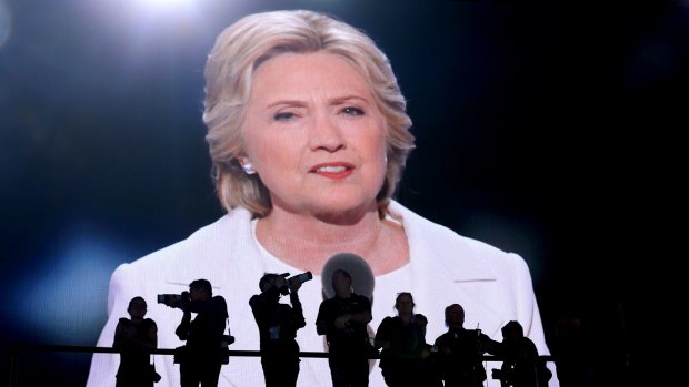 Photographers stand as Hillary Clinton, 2016 Democratic presidential nominee, is seen speaking on a screen during the Democratic National Convention (DNC) in Philadelphia. Her campaign was marred by the hack.