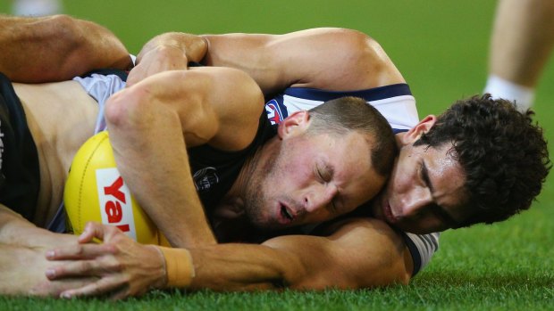 Former Cat James Kelly is tackled by Nakia Cockatoo in his 300th game.