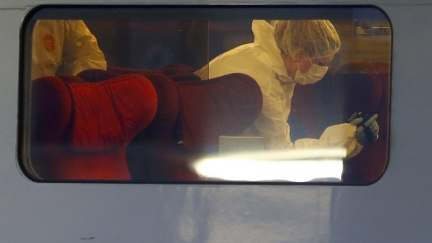 A French policewoman takes a photo of the crime scene in the Thalys high-speed train where shots were fired in Arras, France.