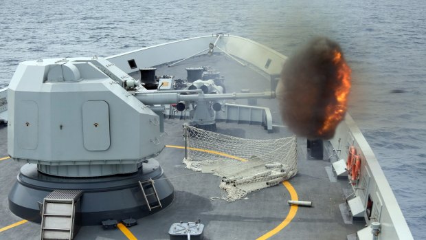A photo released by China's Xinhua News Agency shows anti-surface gunnery fired from China's Navy missile frigate Yulin during exercises in the South China Sea. 