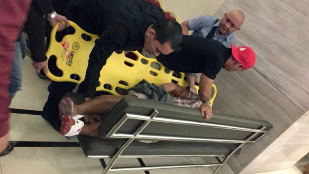 An injured man is placed on a stretcher after explosions rang out in Manila.