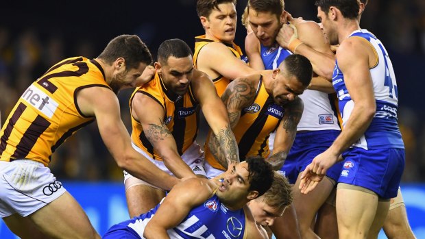 Players wrestle after a bump by the Roos' Jack Ziebell on Hawk Sam Mitchell in their round 13 clash. 