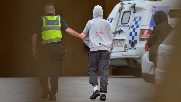 A boy is taken into Frankston police station on Friday for questioning.