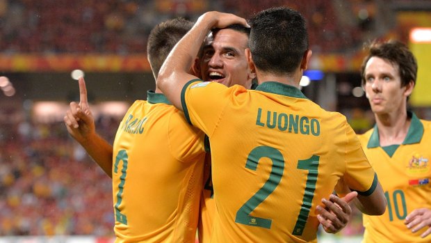 On target: Tim Cahill is congratulated on scoring against China.