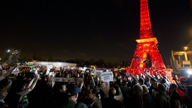 Activists gather next to a mini Eiffel Tower after a sit-in protest to denounce a draft text released at the climate conference.