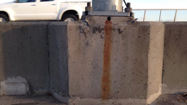 Signs of rust and discoloration at the bases of the bridge light towers.