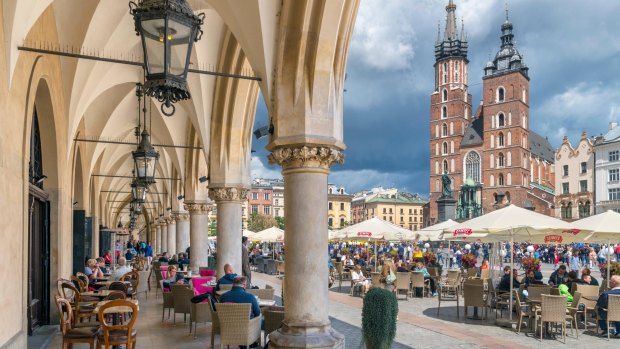 PF1E4H Krakow Old Town. View of St Mary's Basilica and the Main Square ( Rynek Glowny ) from a cafe in the Cloth Hall (Sukiennice), Krakow, Poland credit Alamy one time use for Traveller only FEE APPLIES Whitley - town squares