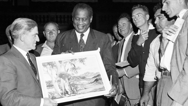 Robeson is presented with an Albert Namatjira painting during a mass meeting of waterside workers at Sydney Town Hall on 11 November 1960