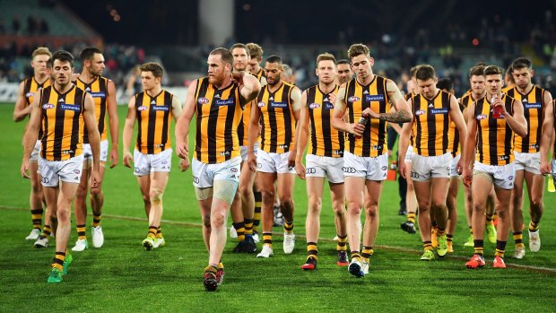 How the mighty Hawks have fallen: a dejected Hawthorn side leaves the field.