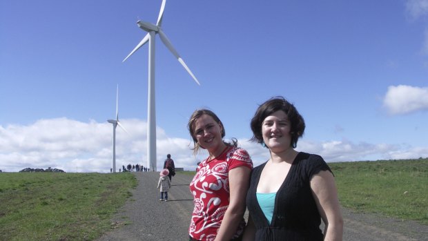 Jarra Hicks and Nicky Ison with the two wind turbines, Gale and Gusto, at Hepburn Wind.