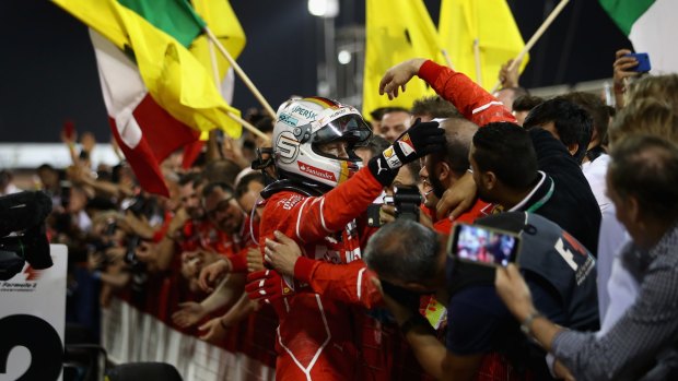 Bahrain race winner Sebastian Vettel celebrates with his Ferrari team.