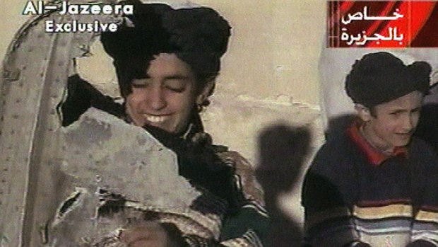 A young boy, left, identified as Hamza bin Laden holds what the Taliban say is a piece of US  helicopter wreckage in Ghazni, Afghanistan in November 2001. 
