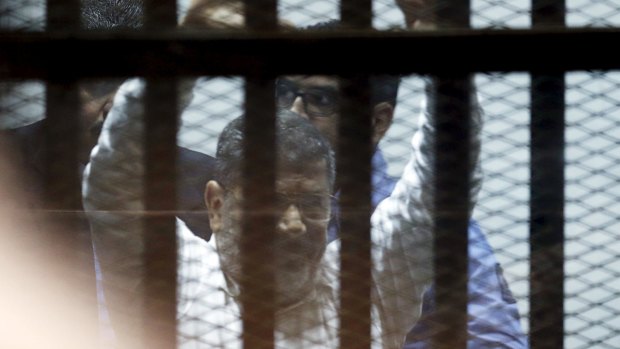 Ousted Egyptian president Mohamed Mursi waves to supporters after he received a 20-year jail sentence. 