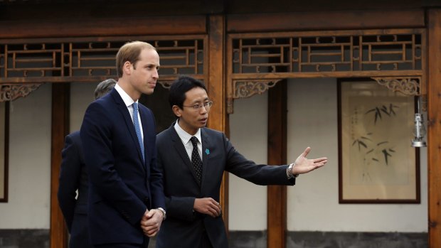 Prince William, left, is guided by Matthew Hu, China representative of the Prince's School of Traditional Arts while he visits the Shijia Hutong in Beijing on Monday.
