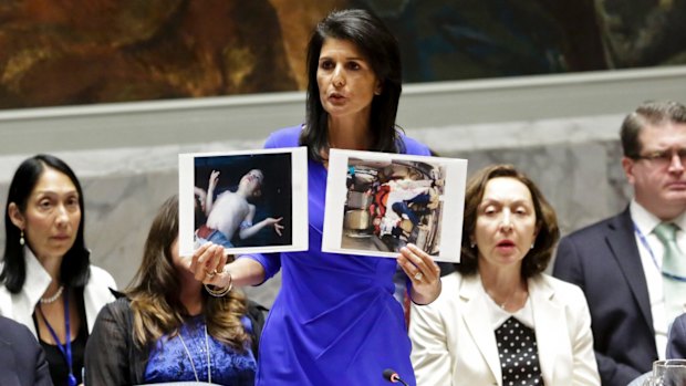 United States' Ambassador to the United Nations, Nikki Haley, holds pictures of Syrian victims.