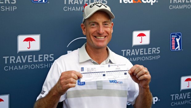 Jim Furyk of the United States poses with his scorecard after shooting a record 58 during the final round of the Travelers Championship at TCP River Highlands in Connecticut.  (Photo by Michael Cohen/Getty Images)