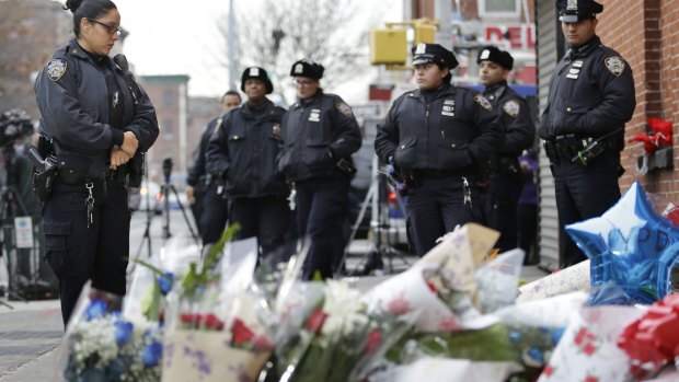 Police officers pay their respects at a makeshift memorial near the site where New York City police officers Rafael Ramos and Wenjian Liu were murdered.