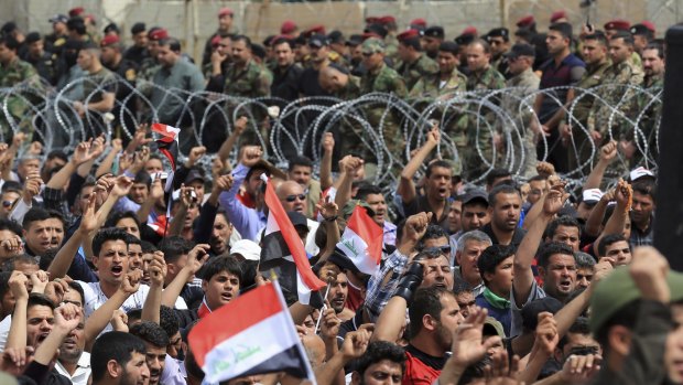 Iraqi security forces guard the heavily fortified Green Zone as followers of firebrand Shiite cleric Muqtada al-Sadr protest in Baghdad on Friday. IS killed dozens of people on Friday night at a soccer match.