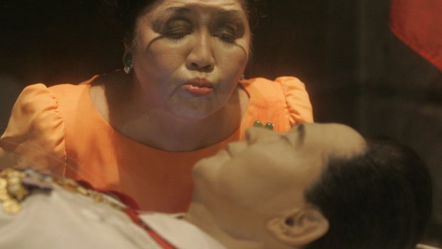 Imelda Marcos kisses the glass coffin of her husband, the late strongman Ferdinand Marcos, in 2010. 