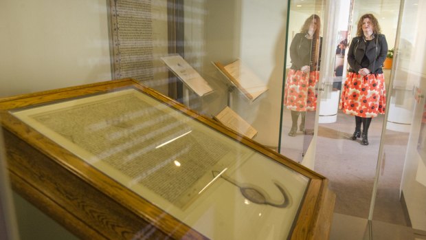 Director of the Parliamentary Art Collection Justine van Mourik with a Magna Carta that is on display at Parliament House.

