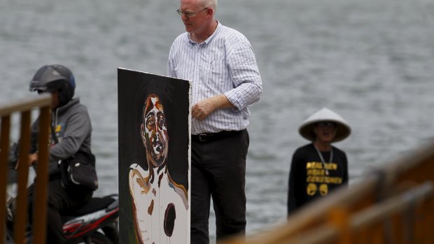 Lawyer Julian McMahon carries what will be the final self-portrait painted by Myuran Sukumaran. 