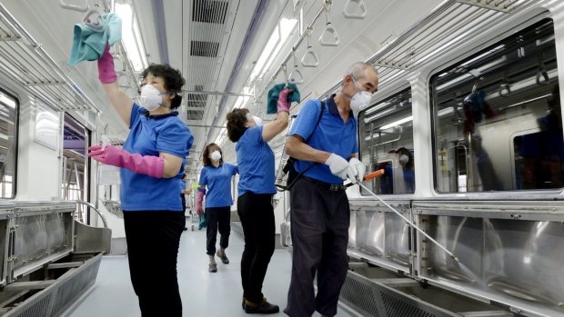 Employees from Seoul Metropolitan Rapid Transit Corp disinfect the interior of a train in Seoul.