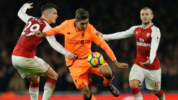 High visibility: Liverpool's Roberto Firmino, centre, vies for the ball with Arsenal's Granit Xhaka .