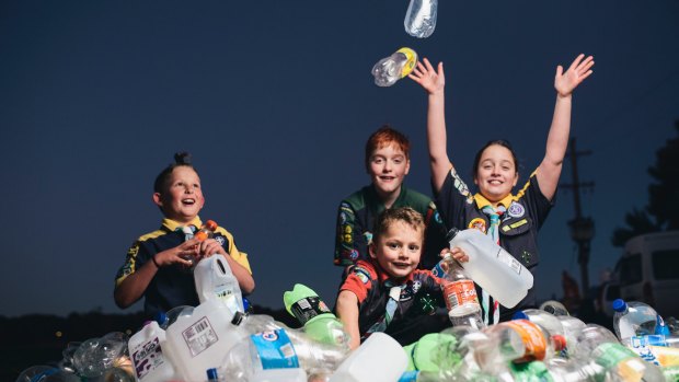 Lake Ginninderra scouts Eli Georgiou, 8, Adrian Lehane, 12, Oliver Georgiou, 6, and Bridget Lehane, 10, with a pile of bottles and cans. Groups like the scouts would benefit from the introduction of an ACT container deposit scheme.