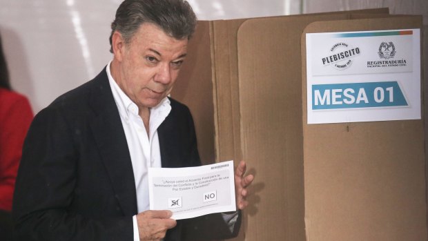 Colombian President Juan Manuel Santos holds his ballot paper in the referendum.