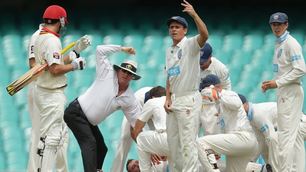 Umpires and players call for help as Hughes hit the ground. 