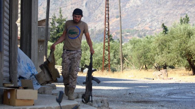 Leaving? A Nusra Front fighter carries weapons in the town of Safsafa in the Hama countryside.