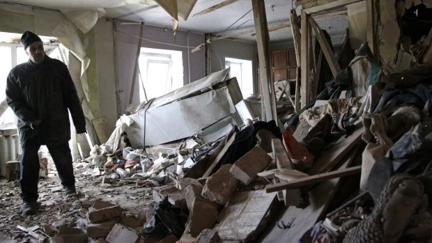 A Donetsk resident surveys the damage to his apartment after it was hit by shelling.