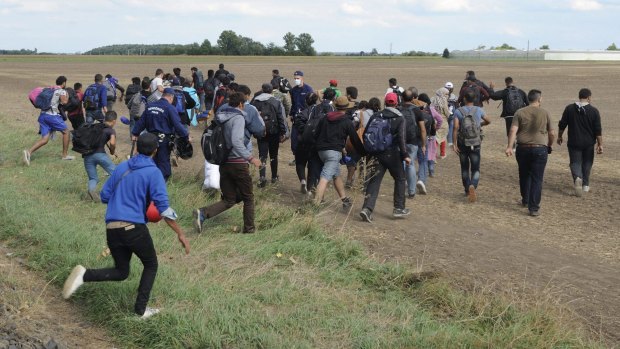 Migrants leave the police reception centre in Roszke to avoid being registered.