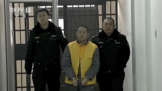 Ding Ning, owner of Ezubao, is escorted by policemen in an unknown location in this image taken from CCTV footage. 