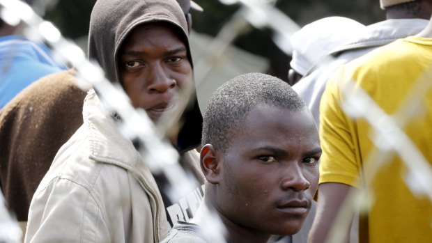 Displaced foreigners  behind razor wire surrounding a tented refugee centre in Primrose near Johannesburg.