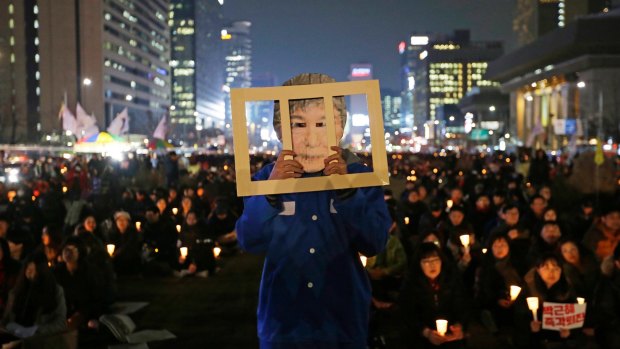 A protester wearing a mask of South Korean President Park Geun-hye performs during a rally calling for Park to step down in Seoul, South Korea on November 30. 