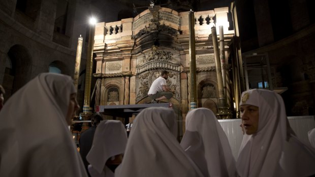 Christian nuns watch as renovation begins at the Church of the Holy Sepulchre in Jerusalem's Old City.