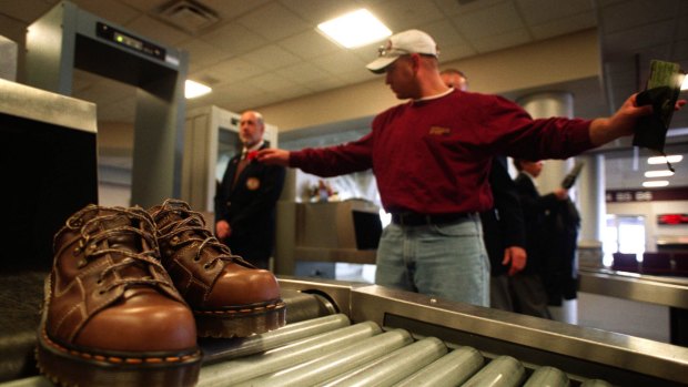 Dave Peterson, of Cedar Rapids, Iowa, is searched by airport security as his shoes roll off the conveyor belt of an X-ray machine at the Eastern Iowa Airport in Cedar Rapids.