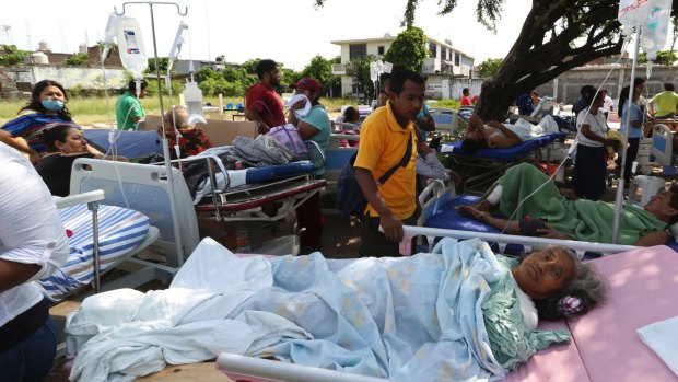 Evacuated patients lie on their hospital beds shaded by a tree, in the aftermath of a massive earthquake, in Juchitan.