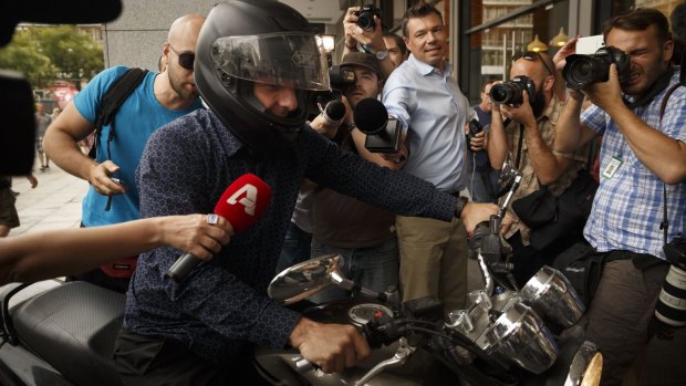 Greece's Finance Minister Yanis Varoufakis gets on his motorbike.
