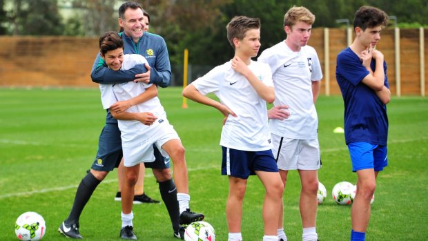 Socceroos assistant coach Ante Milicic lightens things up with Leo Mazis at a clinic at the AIS on Sunday.
